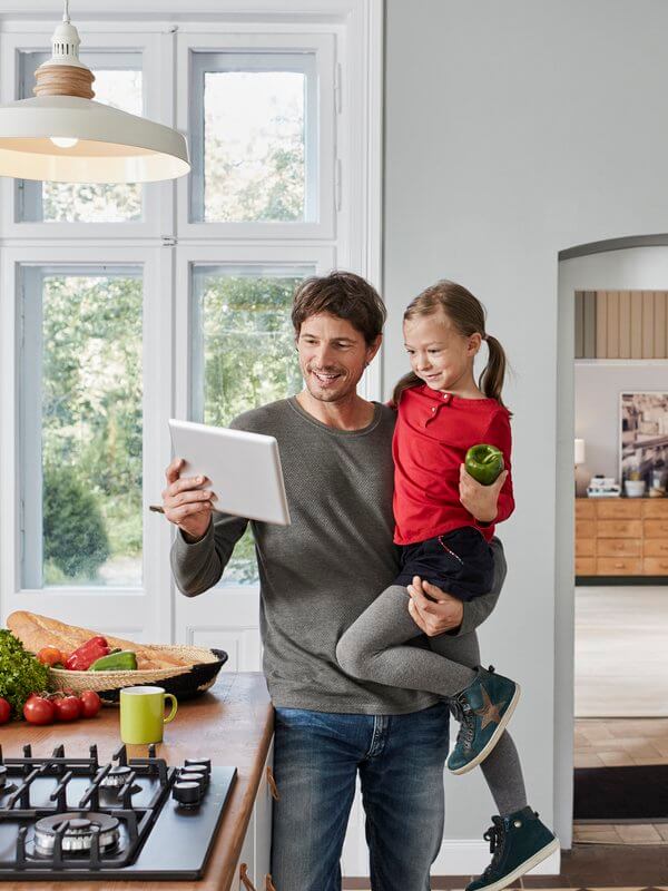 Father with his daughter, using a tablet device to communicate
