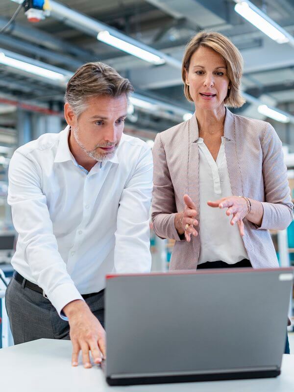 Two colleagues having a conversation while analysing data